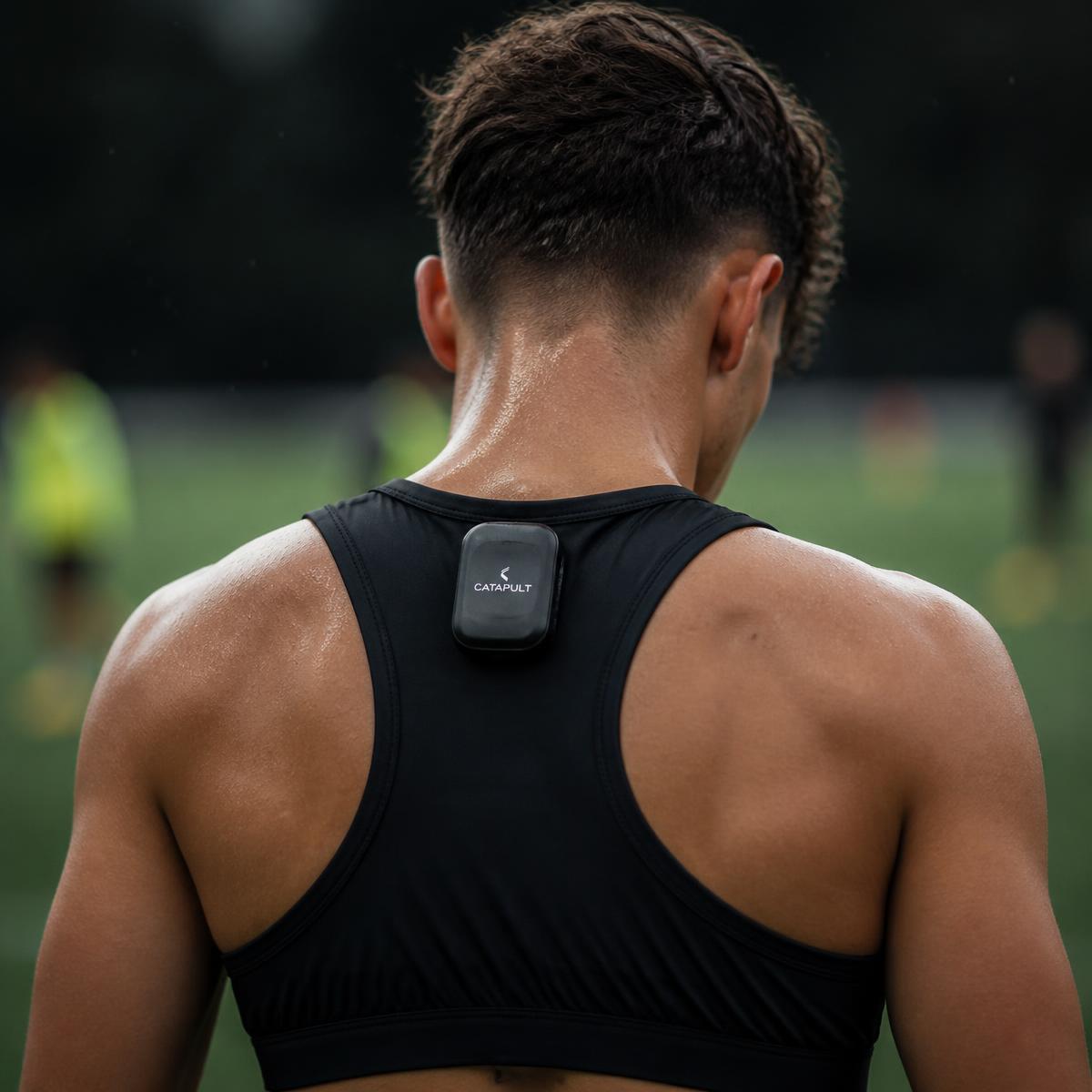 Footballer wearing a black GPS performance vest with the tracking pod between the shoulder blades